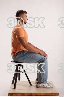 Sitting pose orange thsirt light blue jeans of bodybuilder Harold…